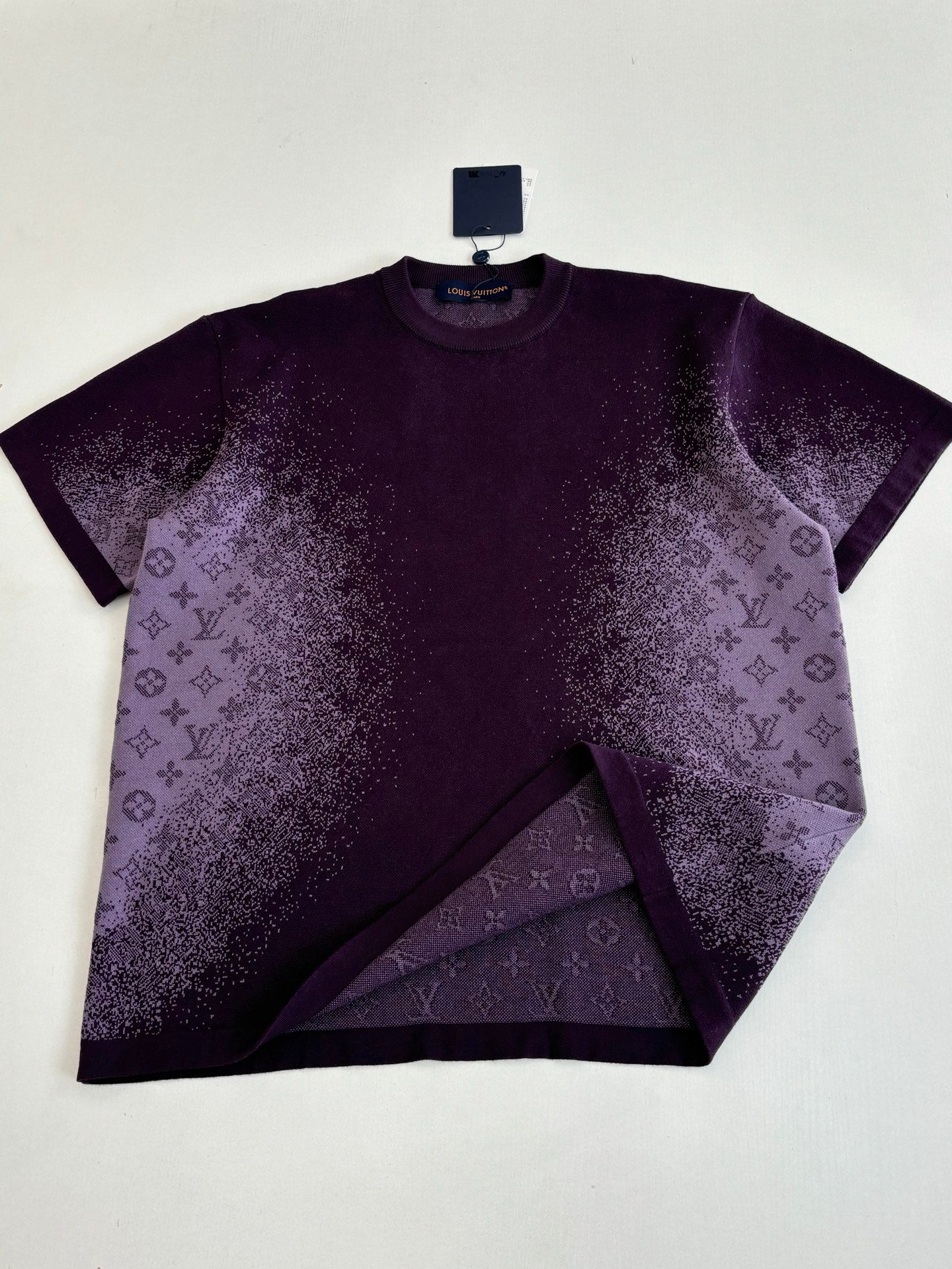 Purple T-shirt with monogram-style allover print, laid flat