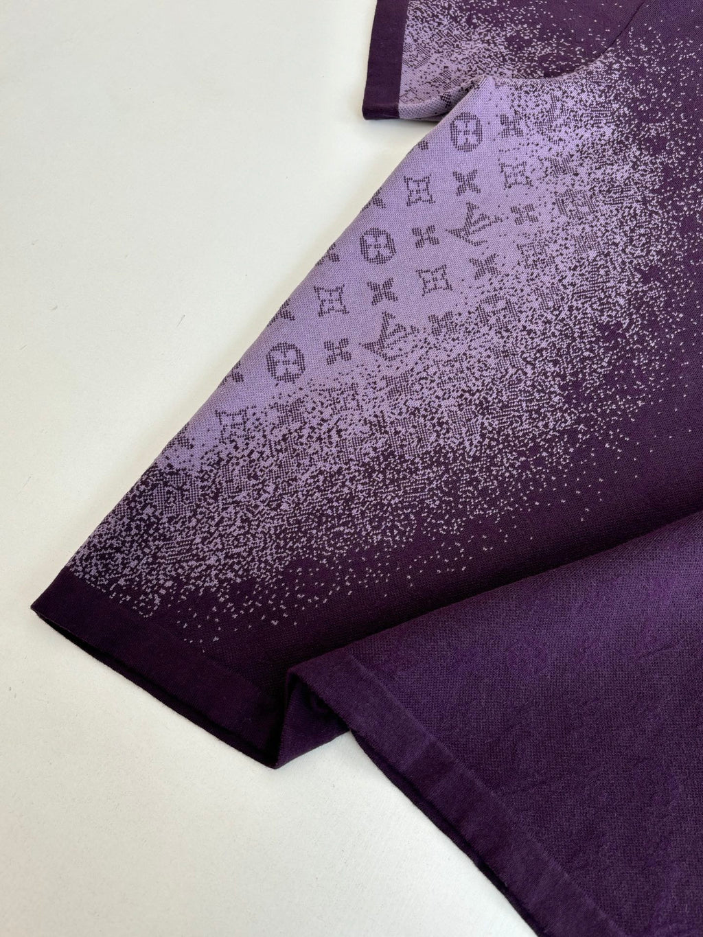 Purple T-shirt sleeve and side seam with monogram-style print