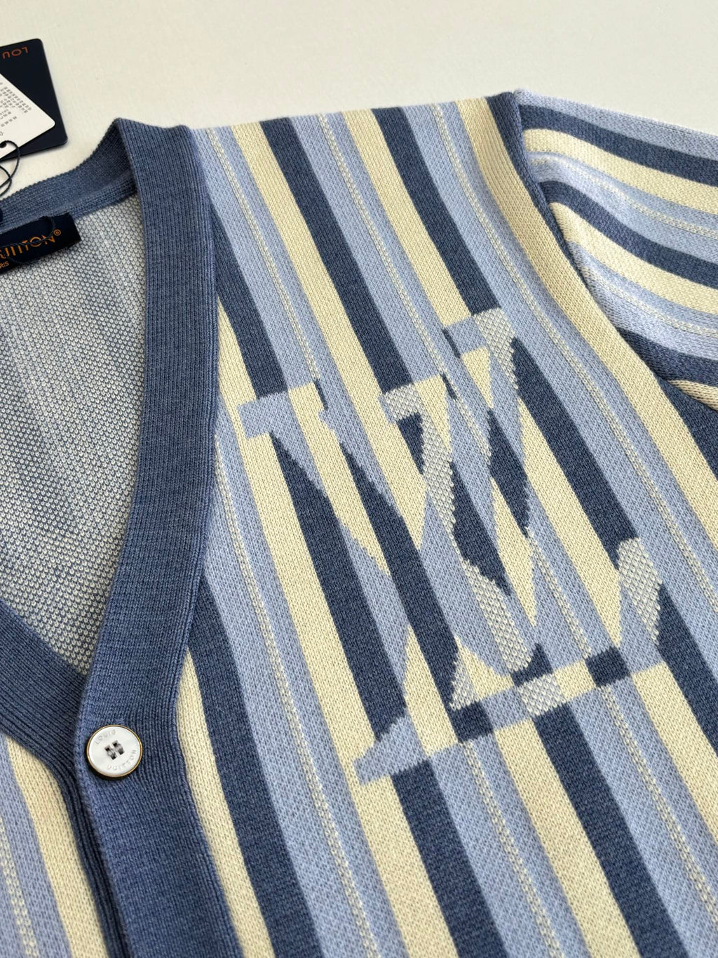 Louis Vuitton striped cardigan sleeve detail with blue geometric monogram motif
