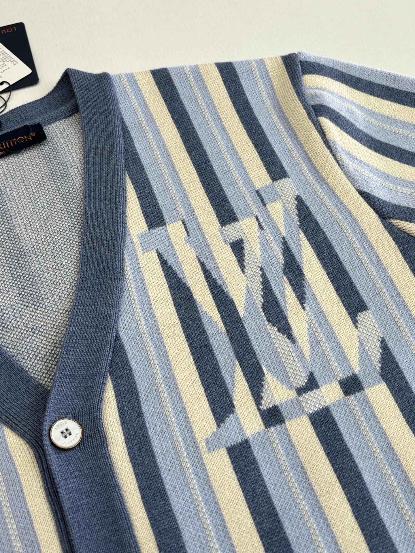 Louis Vuitton striped cardigan sleeve detail with blue geometric monogram motif