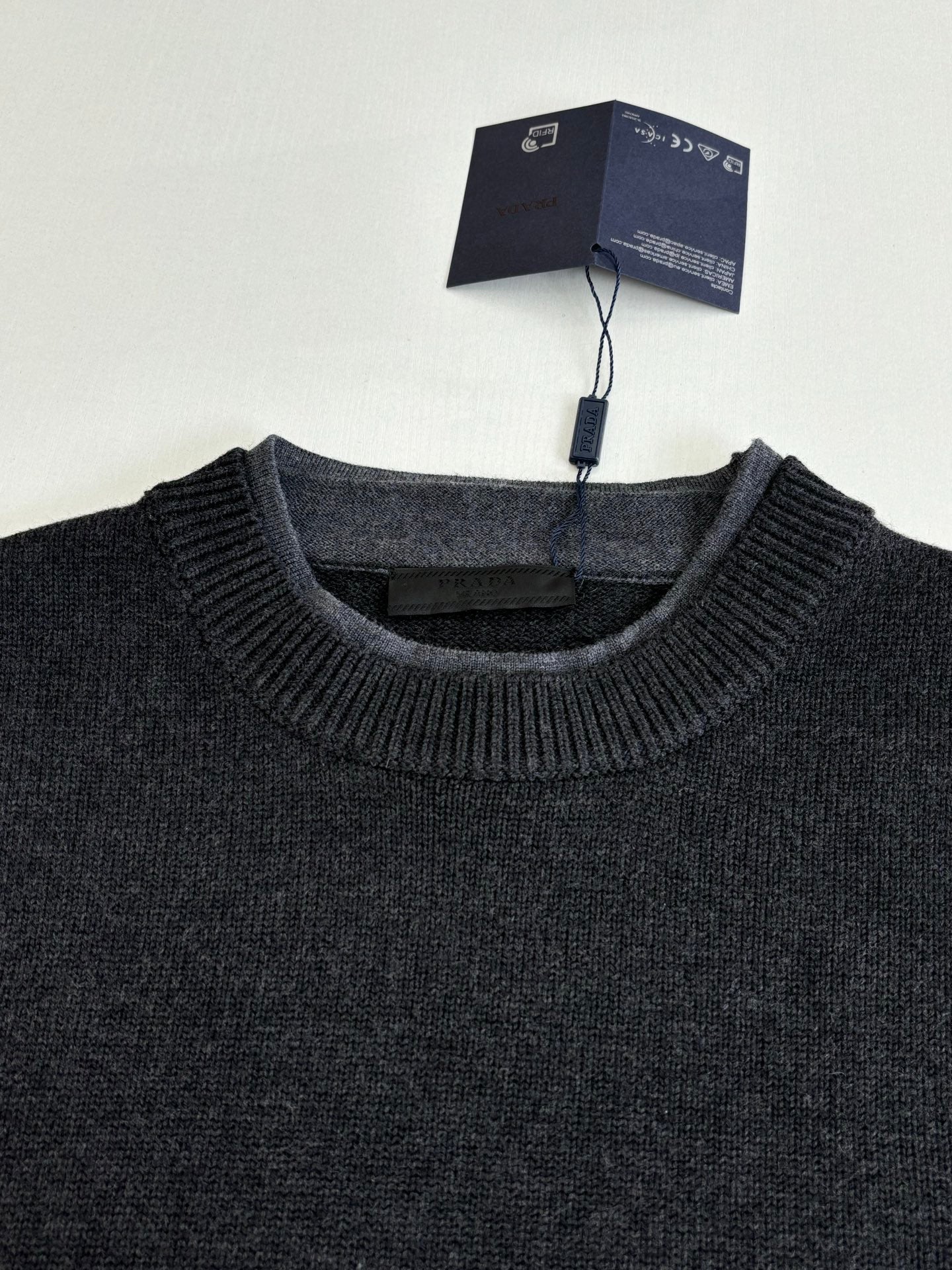 Dark knit crew-neck sweater with ribbed neckline and collar texture