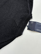 Dark knit sweater hem seam with hang tag attached