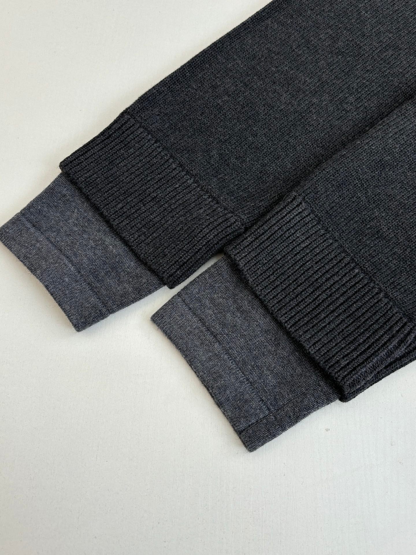 Dark knit sweater cuff and sleeve ribbing close-up