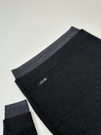 Dark knit sweater folded view with ribbed hem and small Prada tag