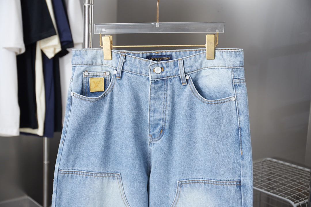 Light blue denim pants front view with button waistband and patch pockets