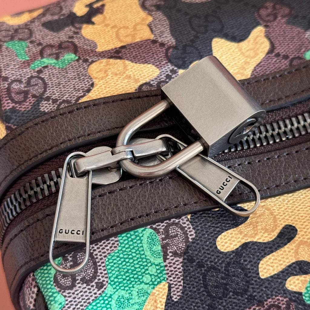 Gucci bag zipper pull with rings and branded key fob on camo fabric