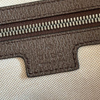 Duffel bag close-up of embossed logo on brown leather trim and zipper track