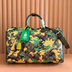 Gucci bag in camo print with top handle, dark trim, and green luggage tag