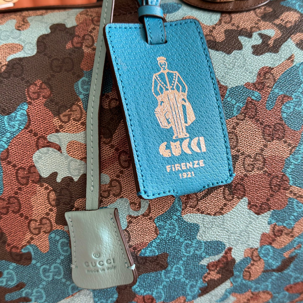 Duﬀel bag close-up of blue leather luggage tag and small white logo tag