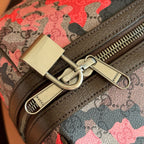 Gucci duffel bag zipper pull and logo hardware on red-and-black camo GG canvas