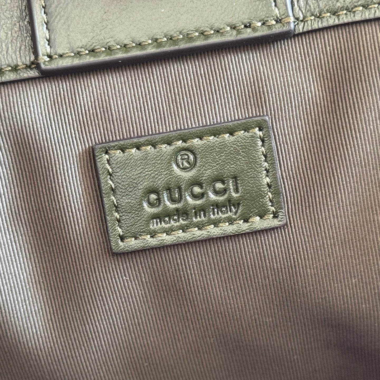 Green fabric Gucci logo patch reading "GUCCI" and "made in Italy"