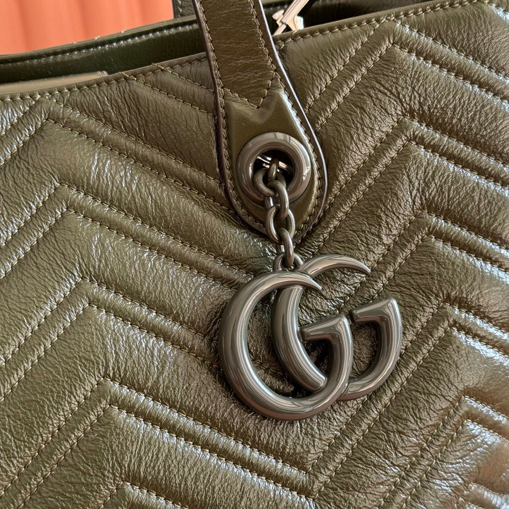 Olive green quilted leather tote close-up of GG chain charm and ring hardware