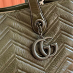 Olive green quilted leather tote close-up of GG chain charm and ring hardware