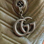 Silver-tone double-G charm detail on textured dark green leather