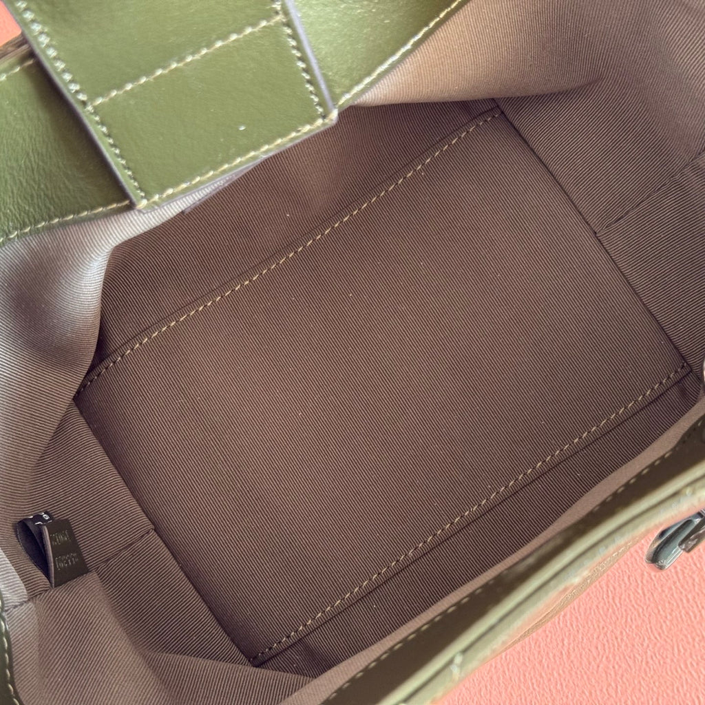 Interior view of dark green bag with beige lining and stitched center pocket