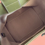 Interior view of dark green bag with beige lining and stitched center pocket