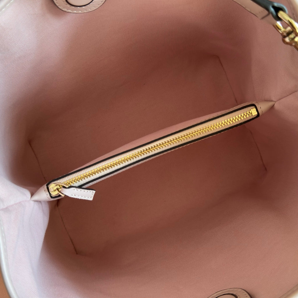 Gucci bag interior with pink lining and gold zipper track, open top view.