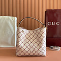 Gucci bag with cream canvas and red lattice pattern, curved top handles, gold hardware.