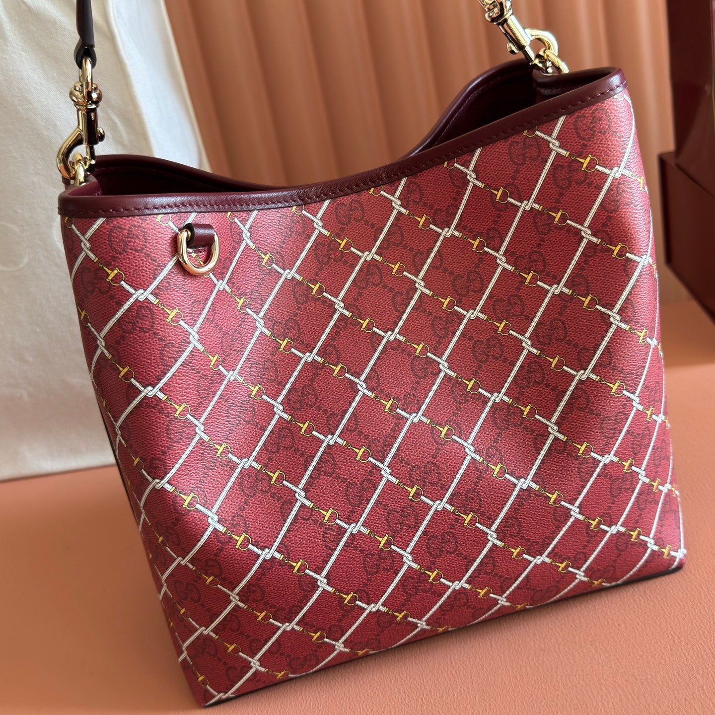 Gucci tote bag with burgundy lattice pattern, curved handles and gold hardware