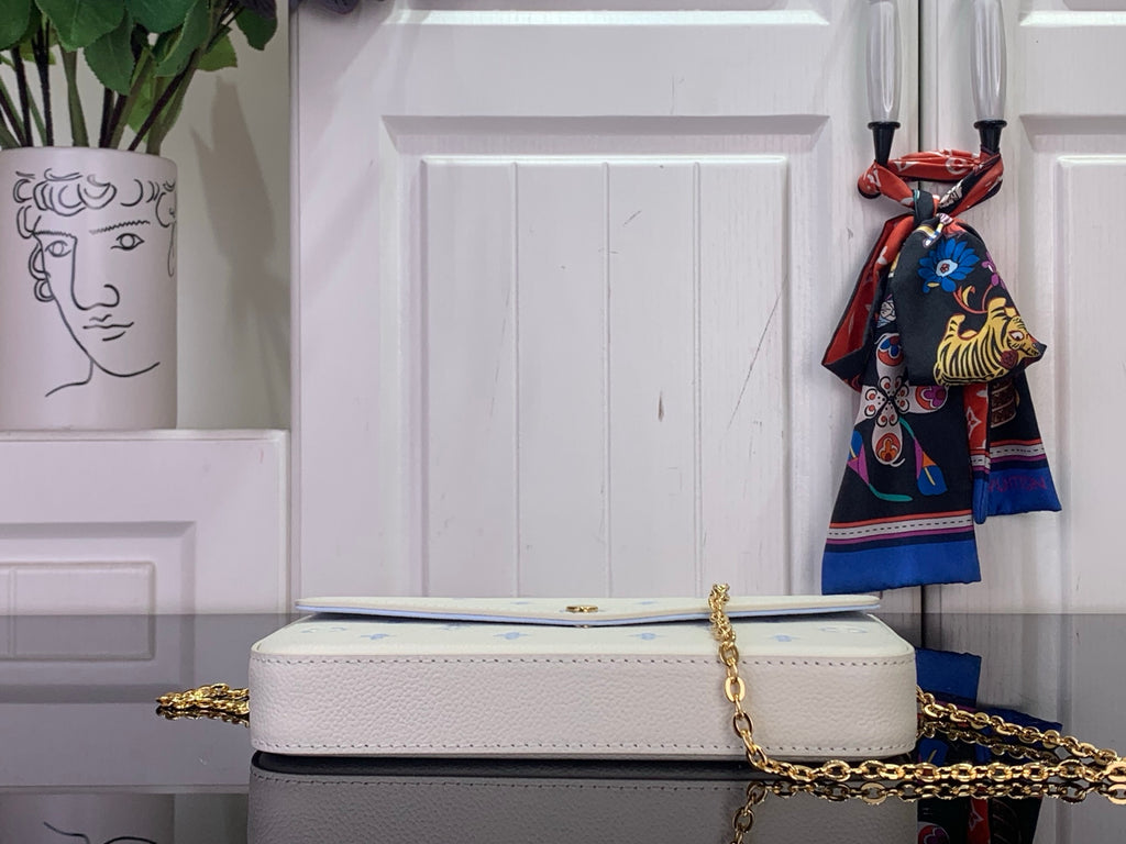 Louis Vuitton crossbody bag with white exterior and blue monogram, gold chain strap detail