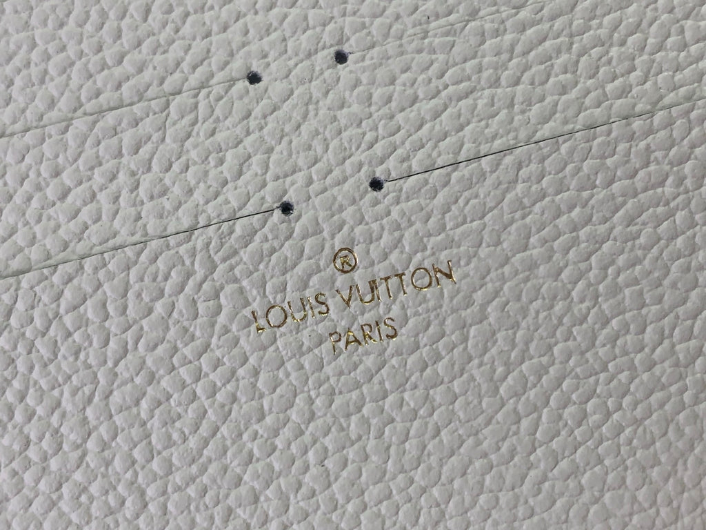 Louis Vuitton embossed logo text on textured light leather, Paris and VUITTON wording