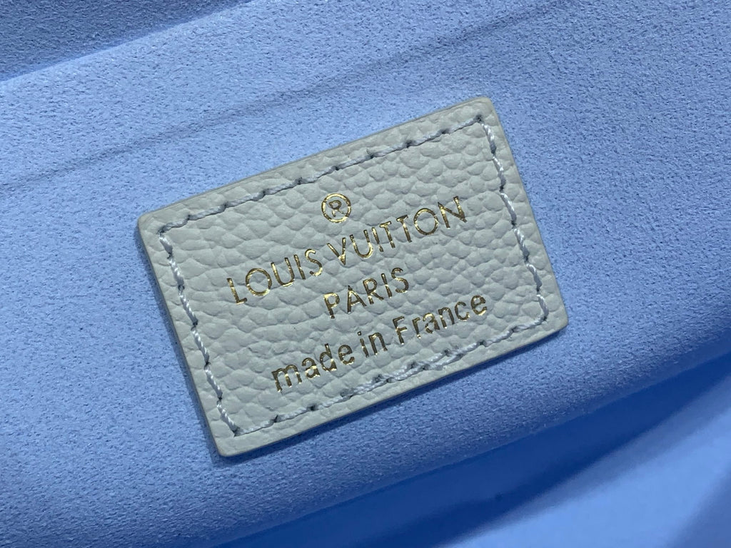 Louis Vuitton leather label patch with 'made in France' text, light blue background
