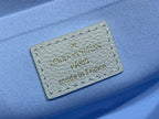 Louis Vuitton leather label patch with 'made in France' text, light blue background