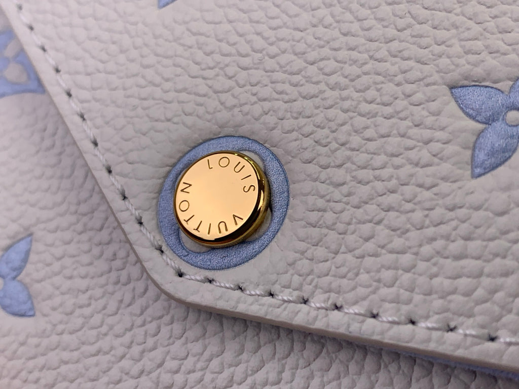 Louis Vuitton logo snap button on light blue textured leather bag