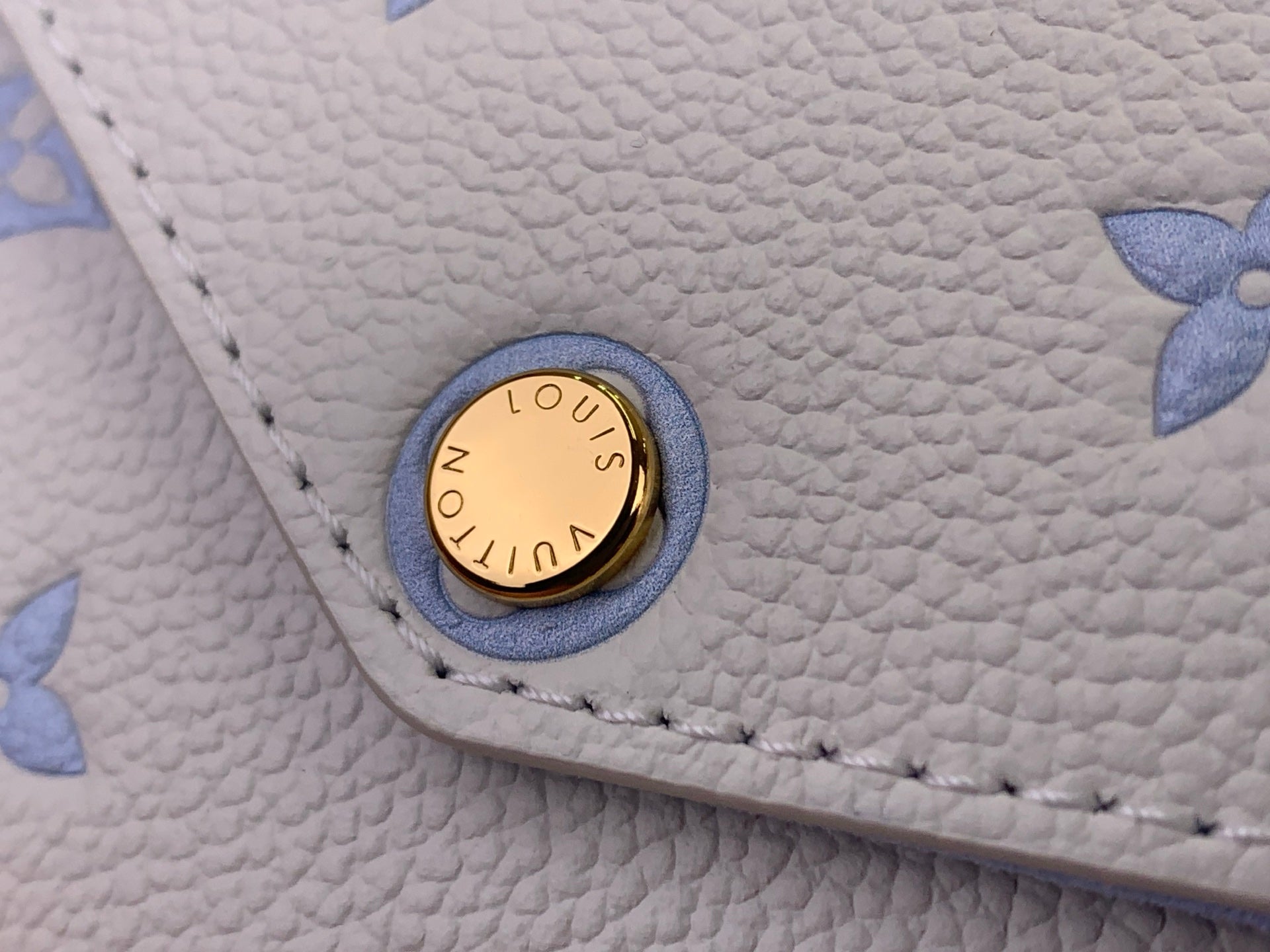 Louis Vuitton logo snap button on light blue textured leather bag
