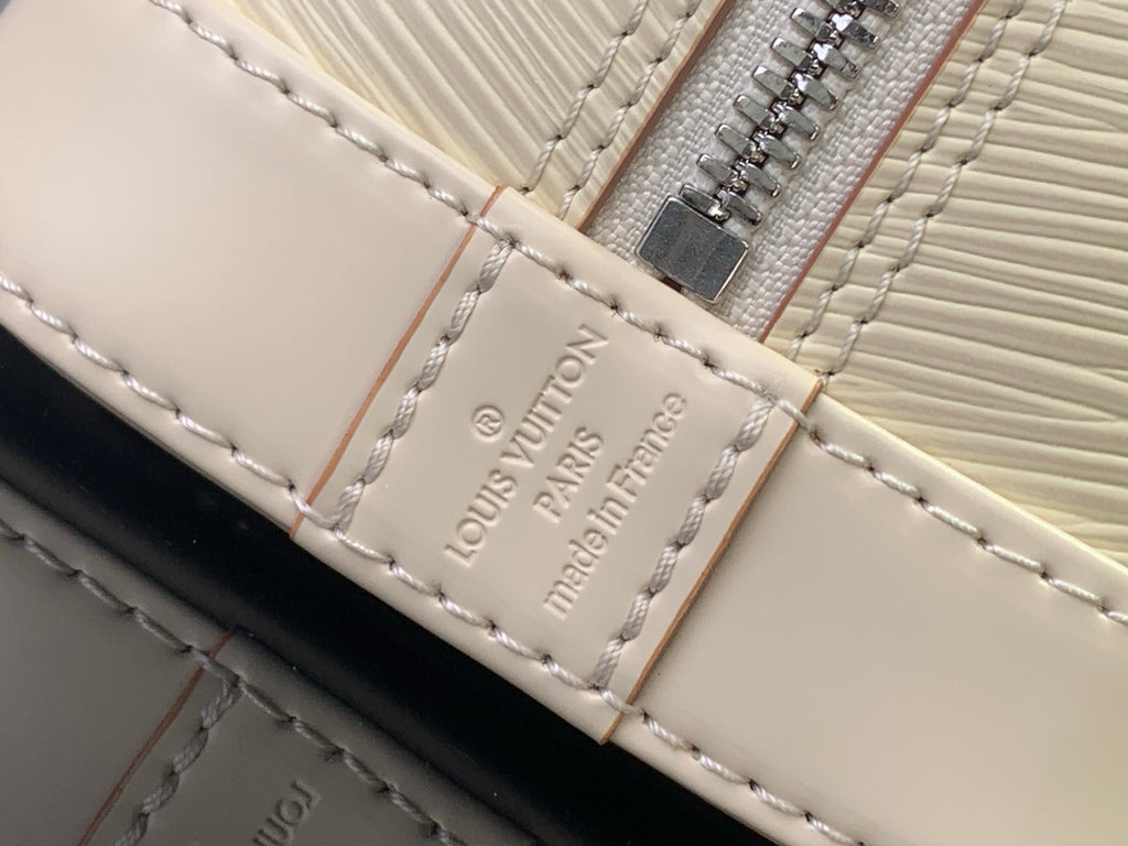 Louis Vuitton logo patch on cream leather strap with visible stitching