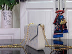 Louis Vuitton crossbody bag with white leather and blue monogram, gold chain strap, side view