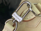 Cream Louis Vuitton handbag with polished metal D-ring and clasp at handle base