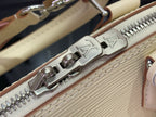 Close-up of Louis Vuitton zipper track and hardware on cream handbag