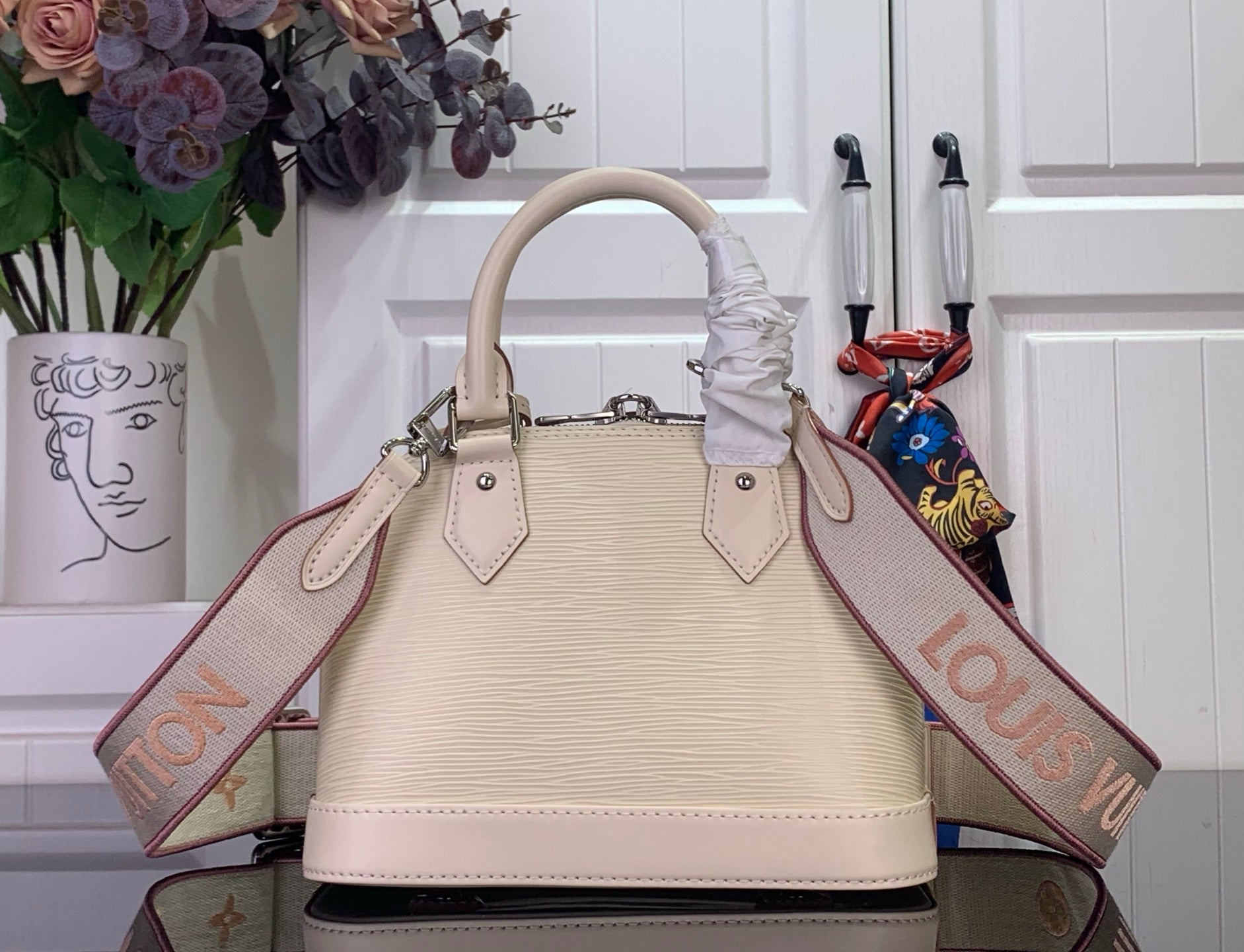 Cream Louis Vuitton handbag with top handles and long logo shoulder strap