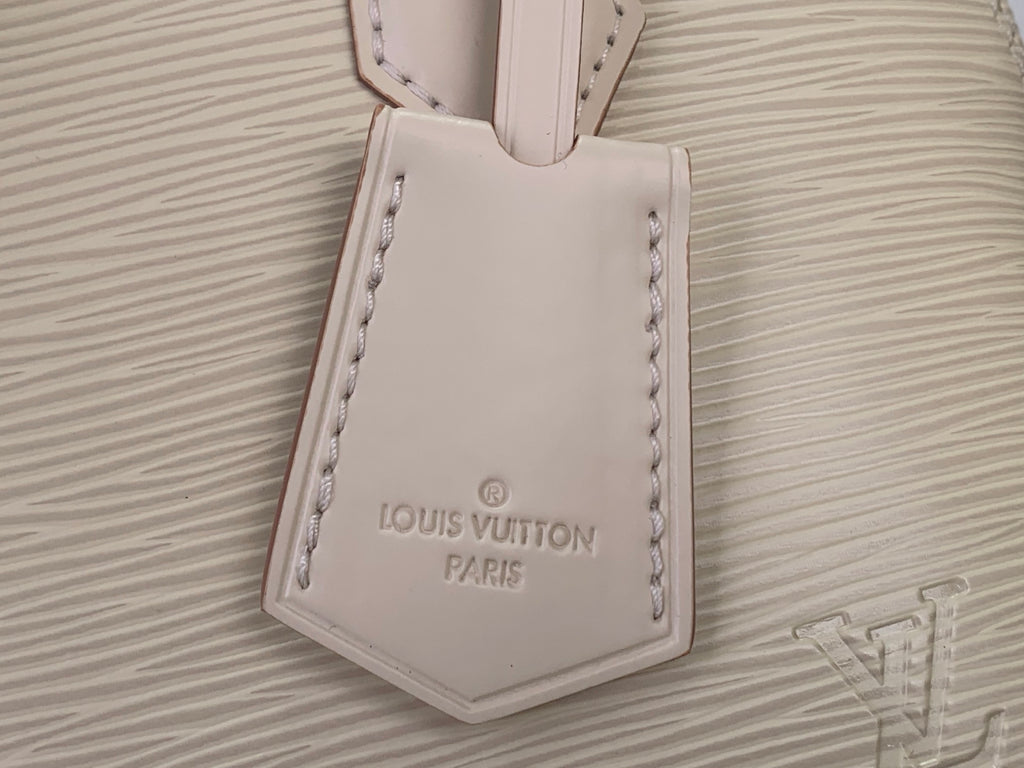 Cream Louis Vuitton leather tag on textured handbag front panel
