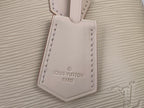 Cream Louis Vuitton leather tag on textured handbag front panel