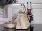 Cream Louis Vuitton handbag with side straps, front zipper area, and hanging tag