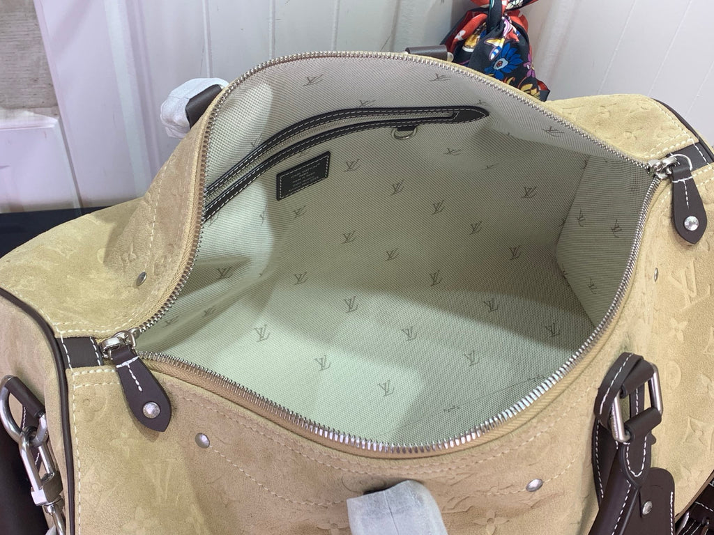 Louis Vuitton bag interior with monogram patterned lining, open top, and zip pocket.
