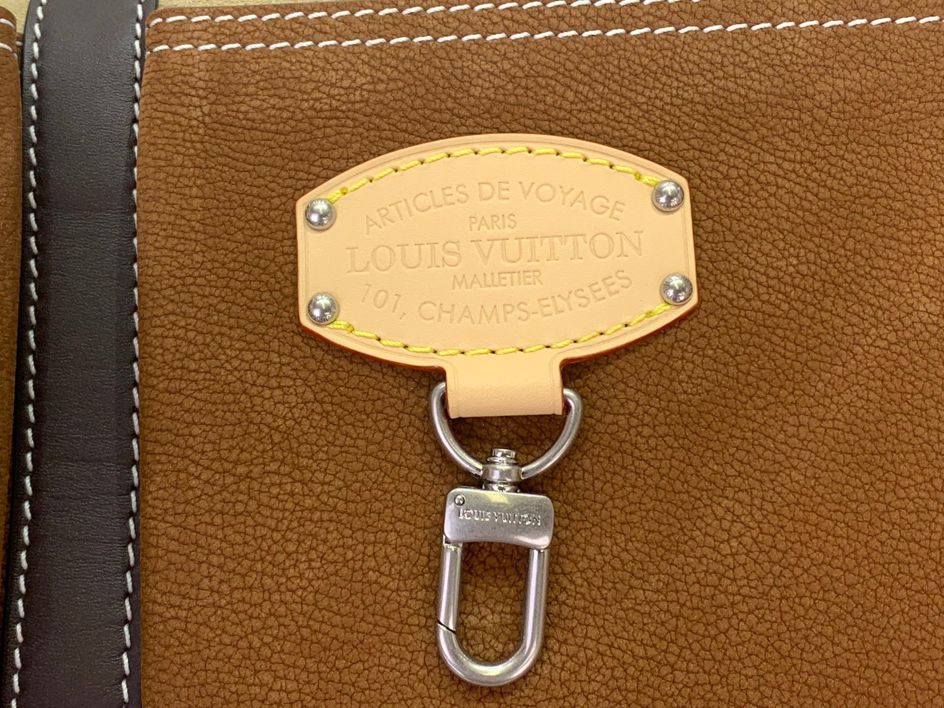 Louis Vuitton bag charm with gold plaque and oval silver carabiner on brown leather