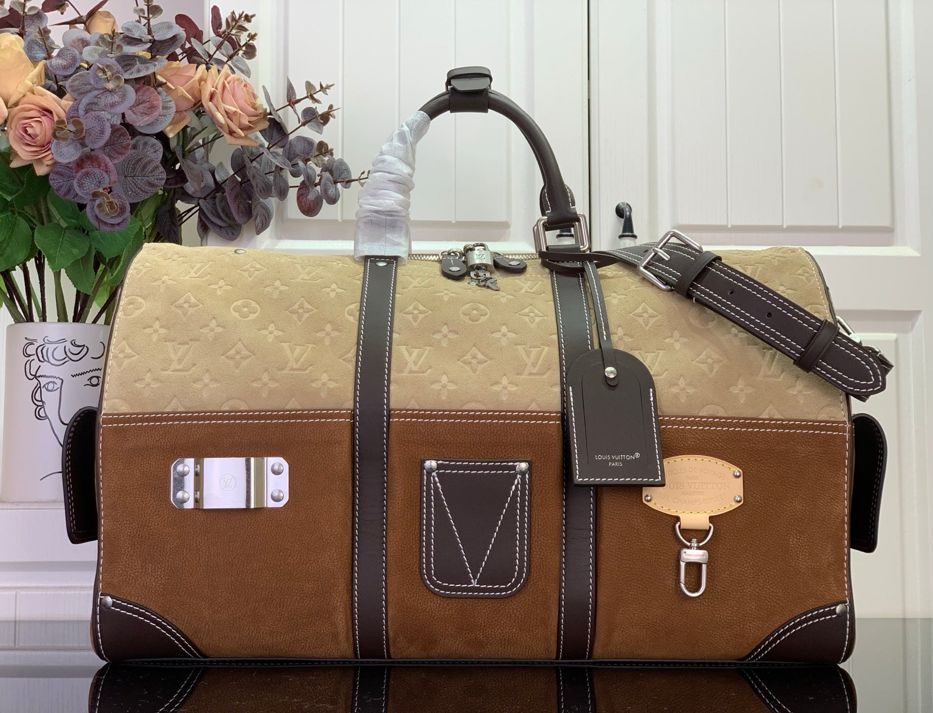 Louis Vuitton duffel bag in brown and tan with dark leather trim, top handles and logo patch