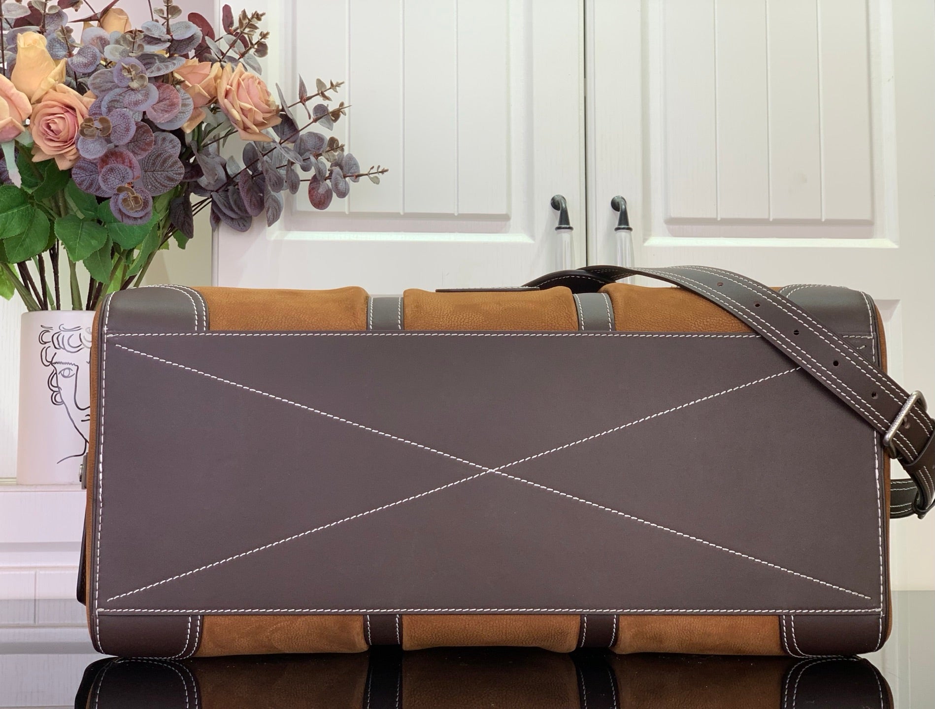 Louis Vuitton bag with dark exterior panel, contrast stitching, and shoulder strap attachment.