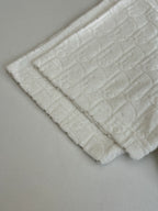 Dior white knit top bottom edge close-up with raised textured pattern