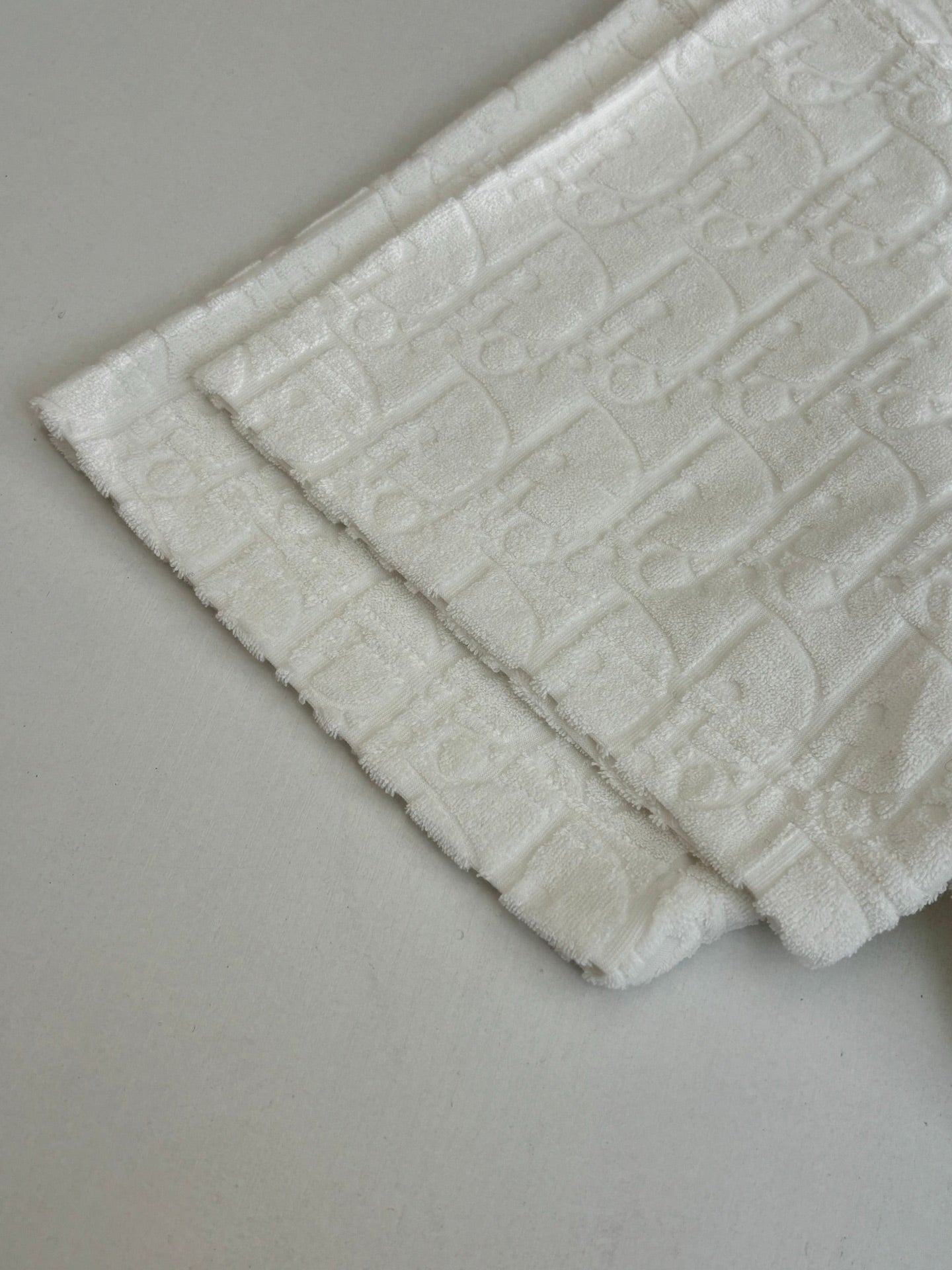 Dior white knit top bottom edge close-up with raised textured pattern