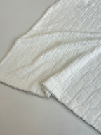 Dior white knit top sleeve and hem close-up with raised textured weave
