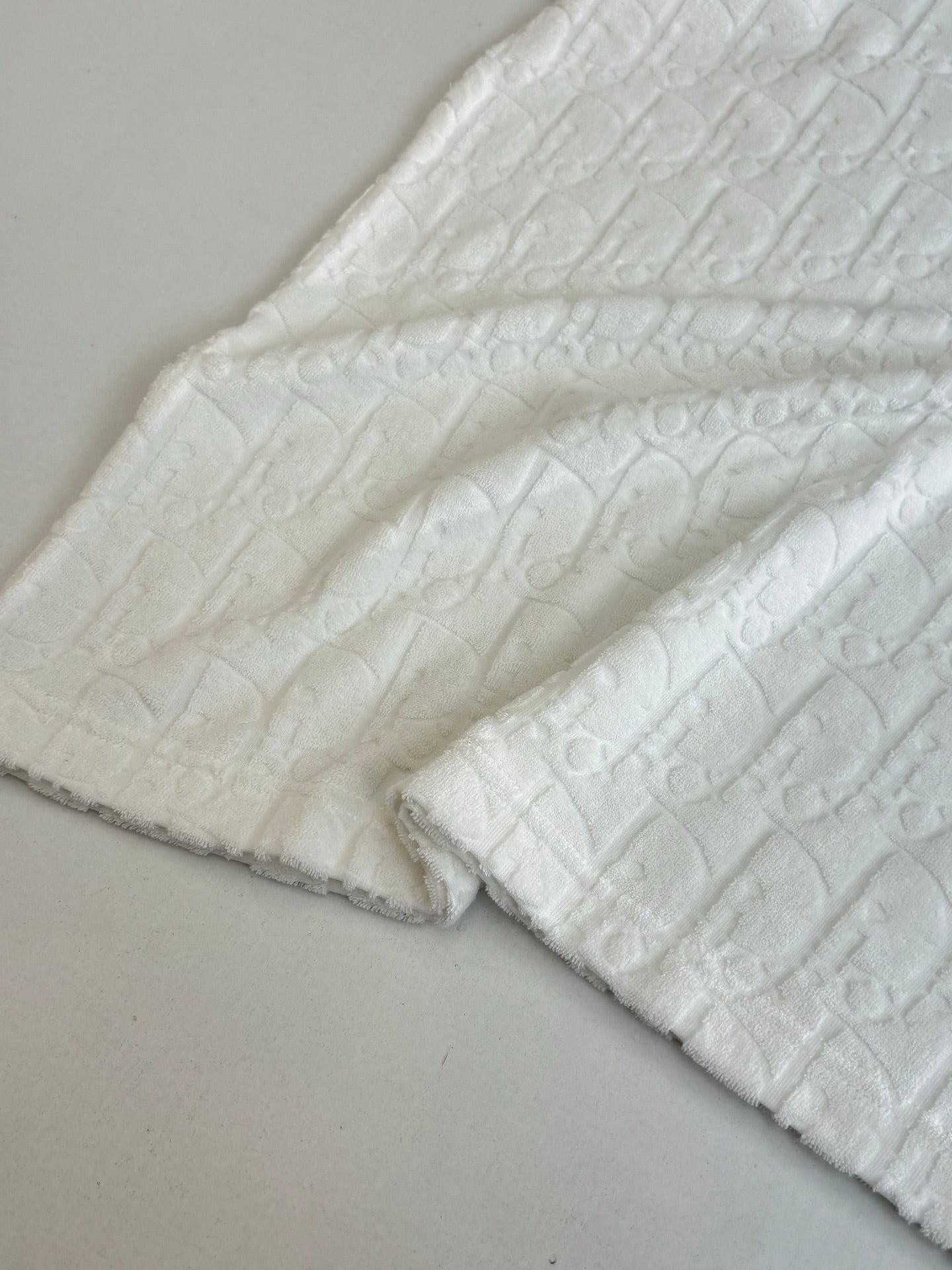 Dior white knit top sleeve and hem close-up with raised textured weave