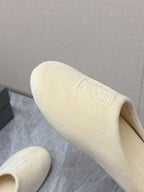 Balenciaga cream slide sandal angled close-up, embossed logo on outer upper