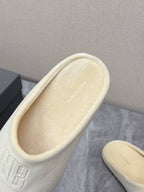 Balenciaga cream slide sandal close-up, embossed logo on cushioned upper