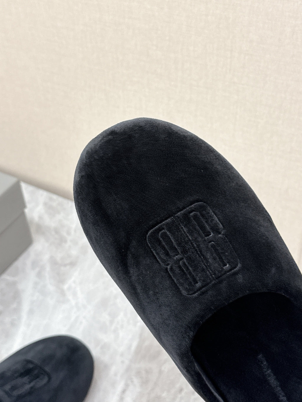 Black velvet slide sandal with embossed Balenciaga logo on upper, close-up