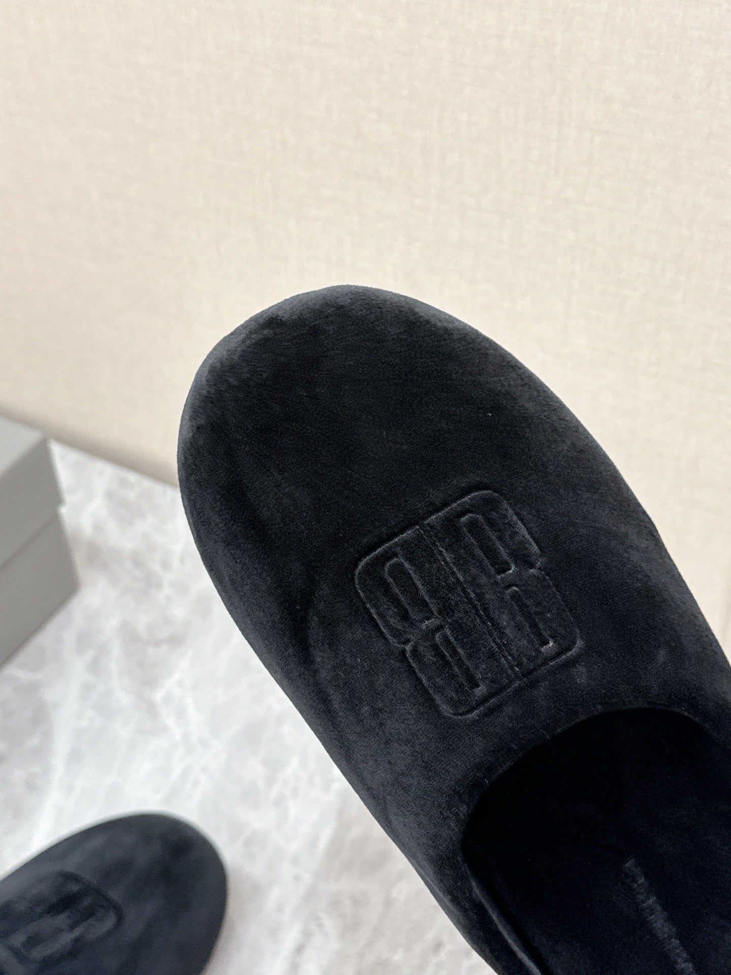 Black velvet slide sandal with embossed Balenciaga logo on upper, close-up