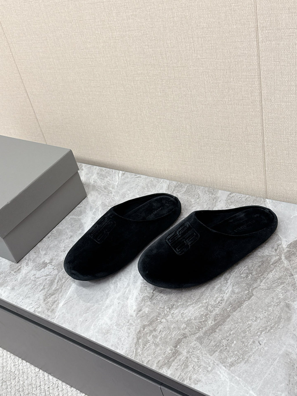Black slide sandals with embossed Balenciaga logo, side-by-side view